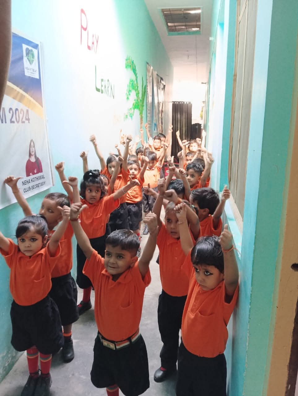 Vidhya Peeth children raising hands straight up in the school corridor